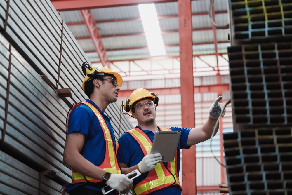 Caucasian,Engineers,Inspecting,Stacked,Steel,Materials,Inside,Industrial,Warehouse,,One